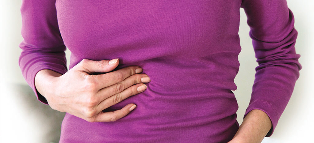 Woman with GERD holding abdomen
