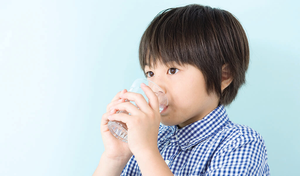young child drinking glass of water