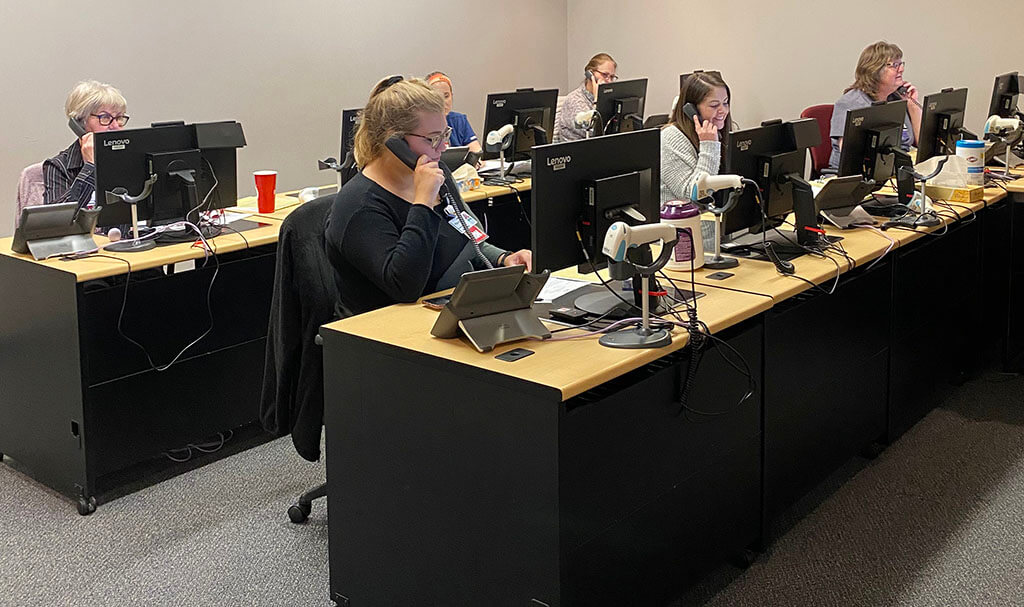 Nurses talking on telephones in a COVID-19 Triage Resource Call Center.